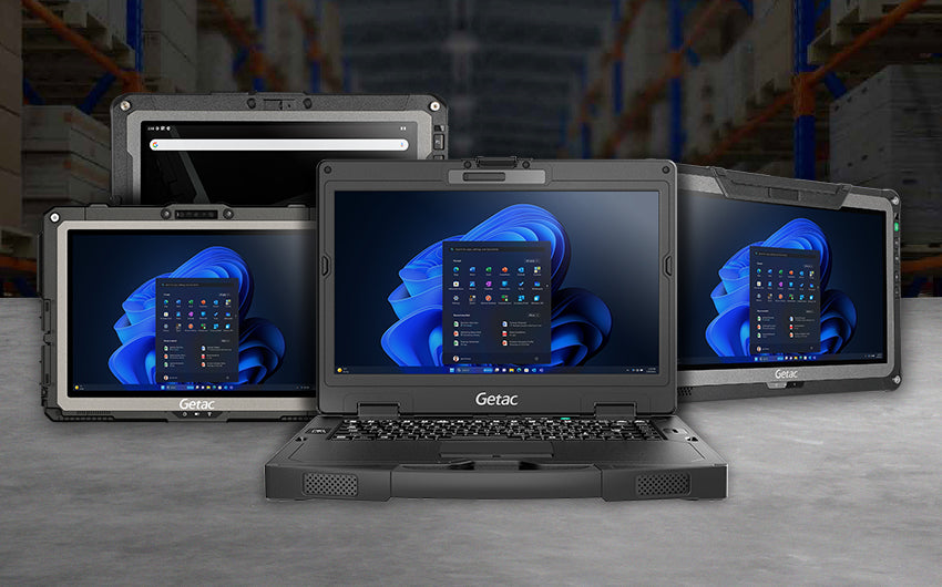 Robuste Tablets und Notebooks von Getac mit Windows 11 Bildschirm, im Hintergrund ist ein Industrie-Lager zu sehen